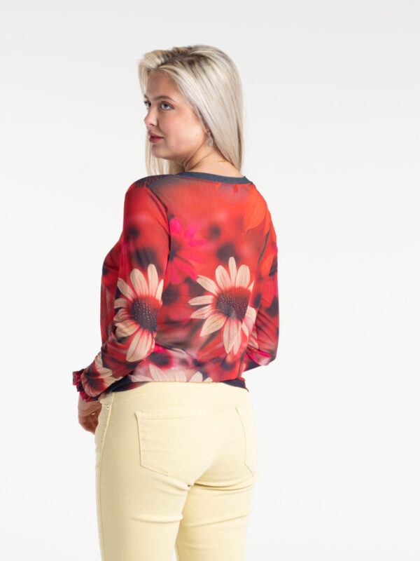 Dahlia Fire Tulle Top by From My Mother's Garden is a striking floral top with a scoop neckline and long sleeves. It has a Dahlia flower print on a red background
