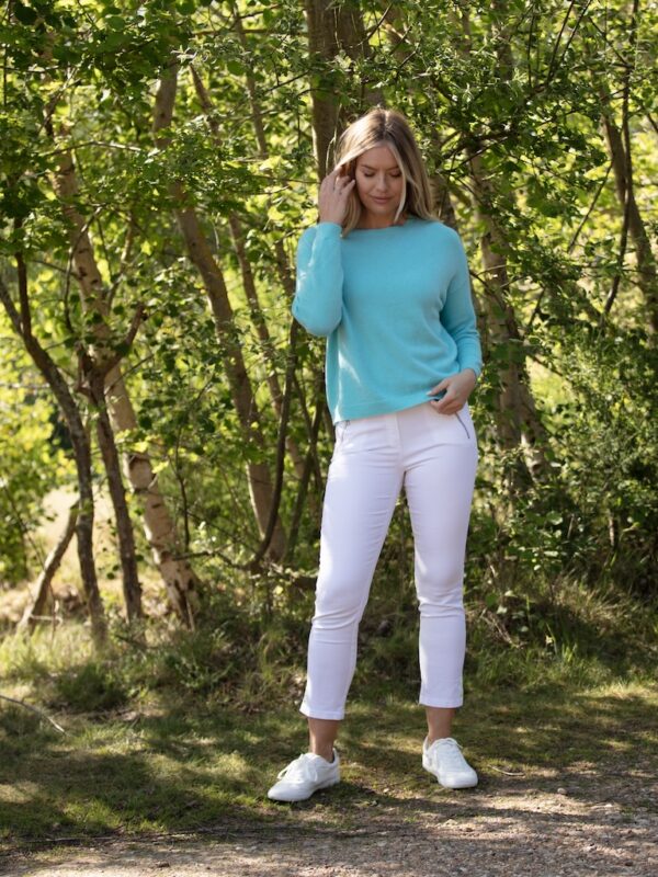 From My Mother’s Garden turquoise knit jumper styled with white jeans outdoors