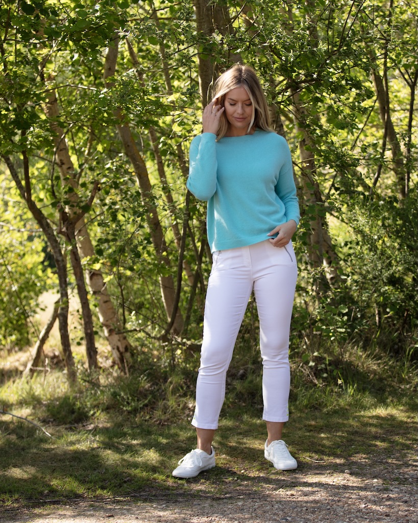 From My Mother’s Garden turquoise knit jumper styled with white jeans outdoors