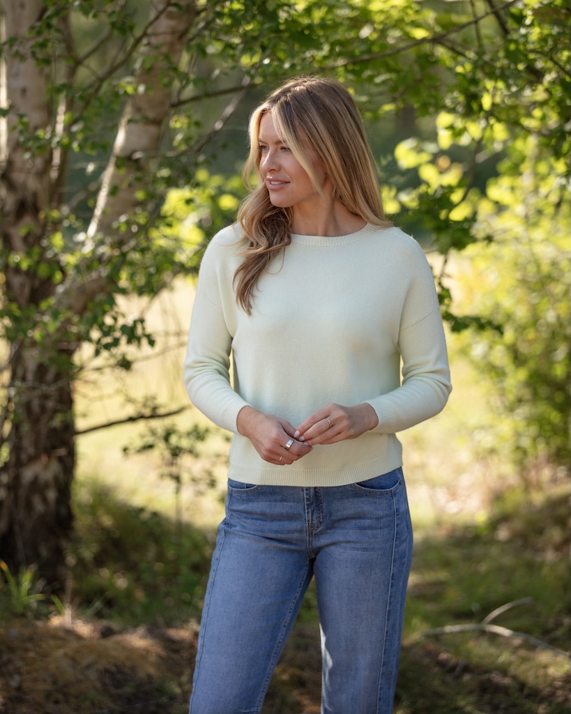 Soft sage lightweight women’s knit jumper styled with blue jeans outdoors