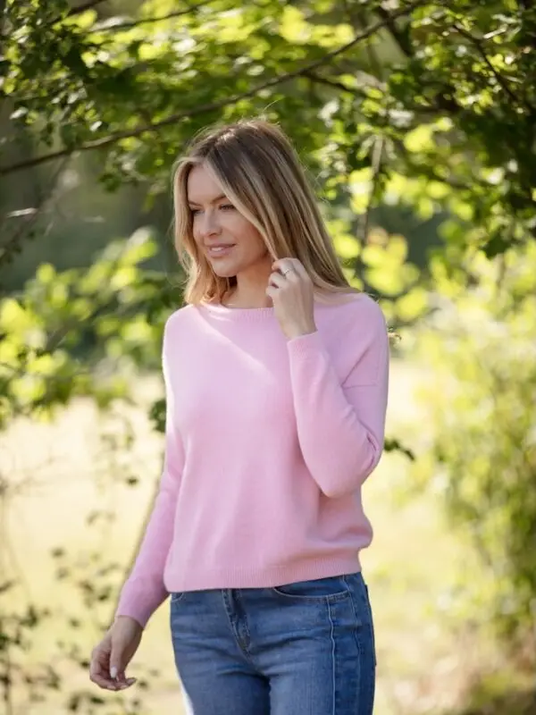 Woman wearing a super soft pink cashmere-feel jumper with dropped shoulders